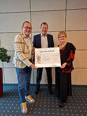 Weihnachtsspende der INFRA Spendenübergabe mit symbolischen Scheck